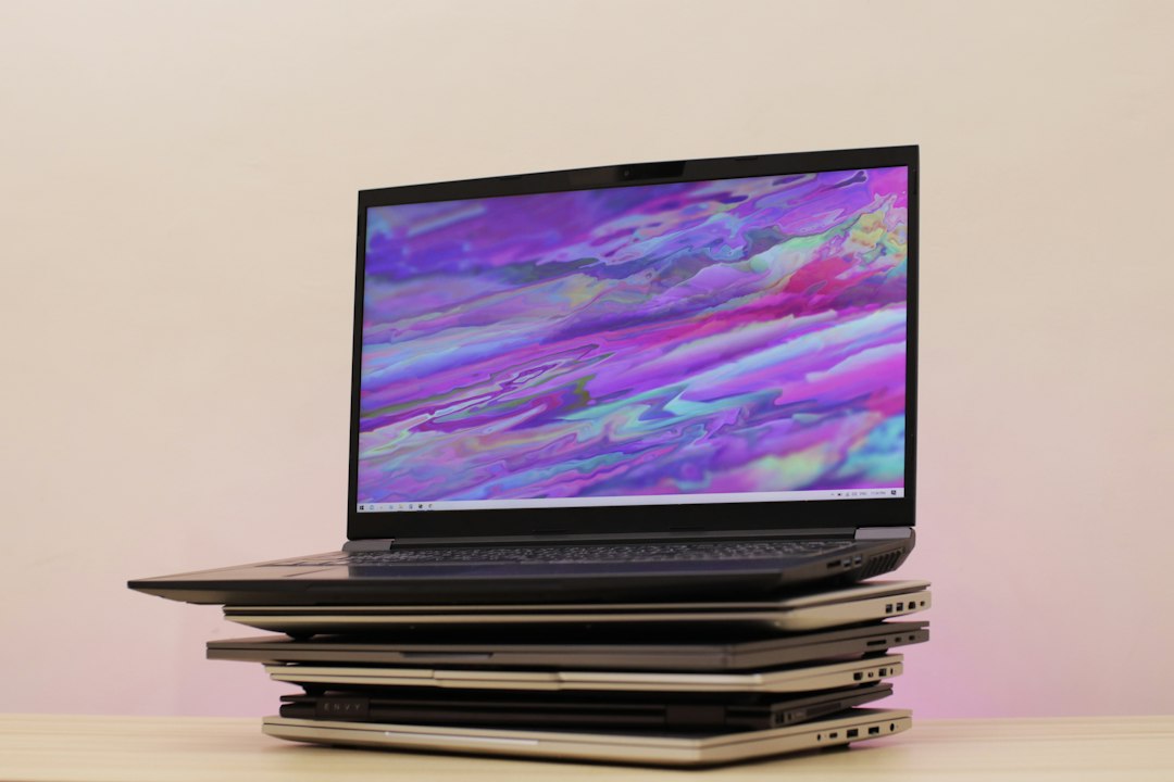 Pile de PC portables reconditionnés et neufs comparés, gaming laptop au sommet — photo Unsplash